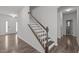 Inviting foyer with hardwood floors, staircase with wooden handrail, and white accents at 1414 Arena Ln, Fuquay Varina, NC 27526