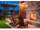 Outdoor seating area with a brick fireplace, string lights and comfortable Adirondack chairs for relaxing at 152 Serene Xing, Fuquay Varina, NC 27526