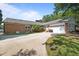 Backyard of brick home featuring a driveway, garage, patio and mature trees at 1732 Edgewood Ave, Burlington, NC 27215