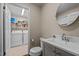 Bathroom with grey vanity, white sink, commode, and a closet with a stacked washer and dryer at 1732 Edgewood Ave, Burlington, NC 27215