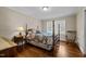 Bedroom featuring hardwood floors, a four-post bed, and neutral paint at 1732 Edgewood Ave, Burlington, NC 27215