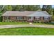 Charming brick home featuring a well-manicured lawn, mature trees, and classic architectural details at 1732 Edgewood Ave, Burlington, NC 27215