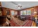 Cozy living room features wood paneling, a ceiling fan, and a plush patterned rug at 1732 Edgewood Ave, Burlington, NC 27215