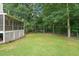 Large backyard with trees providing shade and a screened-in porch on the side of the house at 178 Palmer Dr, Clayton, NC 27527
