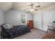 Bedroom with gray walls, a ceiling fan, double closets, and a black bed with a teddy bear at 178 Palmer Dr, Clayton, NC 27527