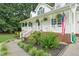 Inviting front porch featuring white railings, greenery, and landscaped garden at 178 Palmer Dr, Clayton, NC 27527