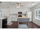 Well-lit kitchen featuring white cabinets, an island, and stainless steel appliances at 178 Palmer Dr, Clayton, NC 27527