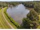 Stunning aerial view showcasing the lake, surrounding trees, and walking path at 2 Lake Village Dr, Durham, NC 27713