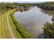 Scenic aerial view of the lake and walking path surrounded by lush trees at 2 Lake Village Dr, Durham, NC 27713