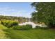 Beautiful backyard with a tranquil lake view surrounded by lush greenery at 2 Lake Village Dr, Durham, NC 27713