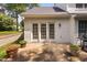 Inviting backyard with concrete patio, lush green lawn, and french doors at 2 Lake Village Dr, Durham, NC 27713