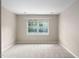 Empty bedroom with carpeting, neutral walls, and a window with a view at 2 Lake Village Dr, Durham, NC 27713