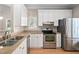 Modern kitchen with stainless steel appliances, light countertops, and white cabinetry at 2 Lake Village Dr, Durham, NC 27713