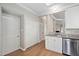 Kitchen featuring stainless steel dishwasher, white cabinets, and wood flooring at 2 Lake Village Dr, Durham, NC 27713