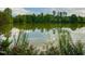 Peaceful pond surrounded by lush trees and colorful flowers under a bright sky at 2 Lake Village Dr, Durham, NC 27713