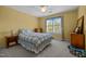 Bedroom features a window, ceiling fan, neutral carpet, and yellow walls at 200 Frenchmans Bluff Dr, Cary, NC 27513