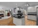 Open-concept kitchen with island, white cabinetry, hardwood floors and modern appliances at 200 Frenchmans Bluff Dr, Cary, NC 27513