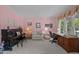 Comfortable living room with a piano, work area, and soft pink walls, offering a versatile space at 200 Frenchmans Bluff Dr, Cary, NC 27513