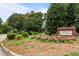 Charming neighborhood entrance with blooming flowers, lush greenery, and a stately brick sign at 200 Frenchmans Bluff Dr, Cary, NC 27513