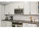 Modern kitchen featuring white cabinets, stainless steel appliances, and subway tile backsplash at 200 S Dawson St # 114, Raleigh, NC 27601
