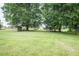 Expansive backyard featuring lush green grass and mature trees, providing a serene outdoor space at 2120 Northcrest Dr, Elon, NC 27244
