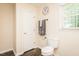 Bright bathroom featuring a toilet, towel rack, wood-look floors, and a window providing natural light at 2120 Northcrest Dr, Elon, NC 27244