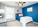 Comfortable bedroom with a blue accent wall, plush carpet, ceiling fan, and plenty of natural light from a window at 2120 Northcrest Dr, Elon, NC 27244