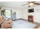 Bright living room featuring a decorative fireplace, mounted TV, hardwood floors and an area rug at 2120 Northcrest Dr, Elon, NC 27244