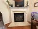 A close up of the fireplace with a marble mantel, electric display, and wall-mounted TV at 2228 Cedar Grove Dr, Durham, NC 27703