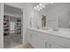 Bright bathroom with dual sinks, a large mirror, and easy access to a large walk-in closet for optimal organization at 2321 Blue Crab Ct, Wake Forest, NC 27587