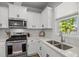 Beautiful kitchen featuring modern appliances, white cabinets, quartz countertops, and classic backsplash at 2321 Blue Crab Ct, Wake Forest, NC 27587