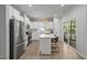 Modern kitchen featuring stainless steel appliances, white cabinetry, island seating, and outdoor access at 2321 Blue Crab Ct, Wake Forest, NC 27587