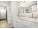 Bathroom with double sink vanity, white cabinets, large mirror, and tiled flooring at 2409 Valley Haven Dr, Raleigh, NC 27603