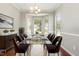 Formal dining room with wainscoting, large windows, chandelier, and seating for six at 2409 Valley Haven Dr, Raleigh, NC 27603