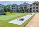 Apartment building exterior with green spaces, putting green, and cornhole game for outdoor recreation at 248 Amber Acorn Ave, Raleigh, NC 27603