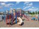 Exterior view of a colorful community playground with slides, climbing structures, and a picnic table at 248 Amber Acorn Ave, Raleigh, NC 27603