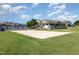 Sand volleyball court surrounded by green lawns and community facilities under a sunny sky at 248 Amber Acorn Ave, Raleigh, NC 27603