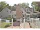 Rear exterior showcasing a brick chimney, white fence, dormer windows, and gray siding at 2708 Coleberry Trl, Rocky Mount, NC 27804