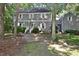 Charming two-story home featuring gray siding, white shutters, and a brick walkway amidst mature trees at 2708 Coleberry Trl, Rocky Mount, NC 27804