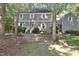 Two-story home boasts gray siding, white shutters, and a brick walkway framed by mature trees and lush lawn at 2708 Coleberry Trl, Rocky Mount, NC 27804
