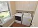 Bright laundry room with washer, dryer, storage cabinets, and natural light at 2708 Coleberry Trl, Rocky Mount, NC 27804