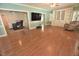 Open-concept living room featuring hardwood floors, a large-screen television, and built-in shelving at 2708 Coleberry Trl, Rocky Mount, NC 27804