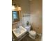 Bathroom featuring a white toilet, sink, decorative cactus and tile flooring at 2915 Ross Rd, Durham, NC 27703