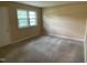 Cozy bedroom with neutral carpeting, a large window, and ample natural light at 2915 Ross Rd, Durham, NC 27703