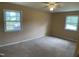 Tan-carpeted bedroom with neutral walls and two windows providing natural light at 2915 Ross Rd, Durham, NC 27703