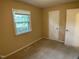 Neutral bedroom featuring neutral walls, carpet, and a window that lets in natural light at 2915 Ross Rd, Durham, NC 27703