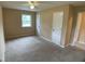 Tan-carpeted bedroom featuring neutral walls, a ceiling fan with a light, and a window letting in natural light at 2915 Ross Rd, Durham, NC 27703