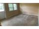 Cozy bedroom with neutral carpeting, a large window, and a door leading to the backyard at 2915 Ross Rd, Durham, NC 27703