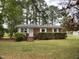 Charming single-story brick home with a well-manicured lawn and mature trees providing shade at 2915 Ross Rd, Durham, NC 27703