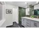 Bathroom with a dual sink vanity, marble countertop, and green tiled accent wall at 301 Lord Berkley Rd, Raleigh, NC 27610
